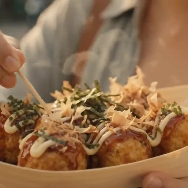 Takoyaki topped with sauce and bonito flakes