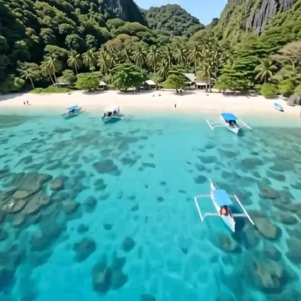 Boats on turquoise water beside a tropical beach